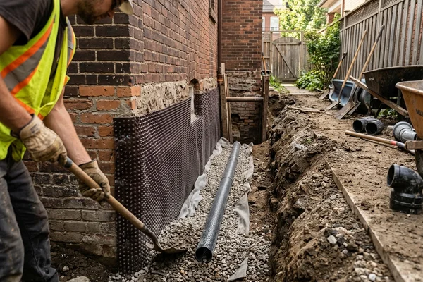 Dimple membrane and weeping tile against an excavated foundation