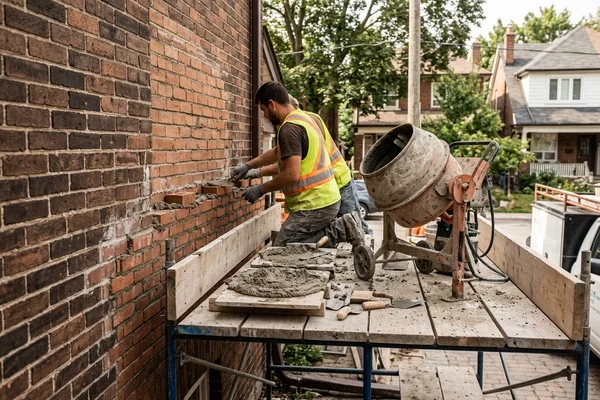 Hydraulic mortar mixer and mortar boards staged on scaffolding