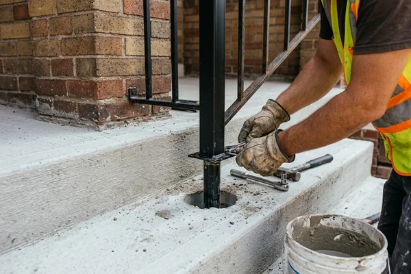 Railing post anchored into a new concrete step