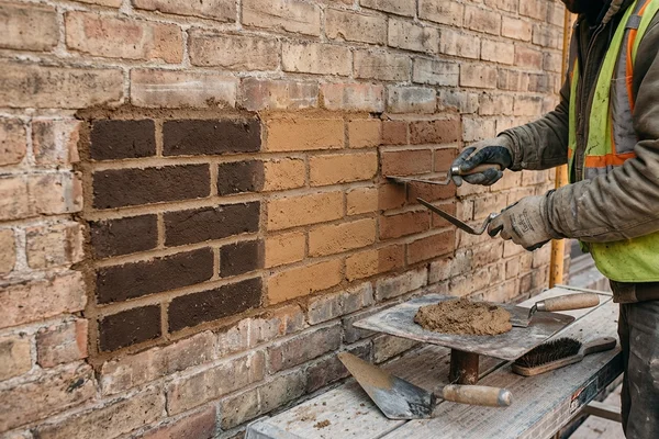 Three lime mortar sample patches on a Victorian brick test panel